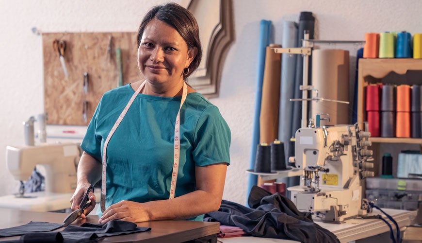 Beautiful woman working in the tailoring industry poses in front of the camera for a portrait.