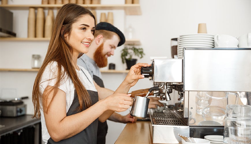 Male and female baristas in a cafe