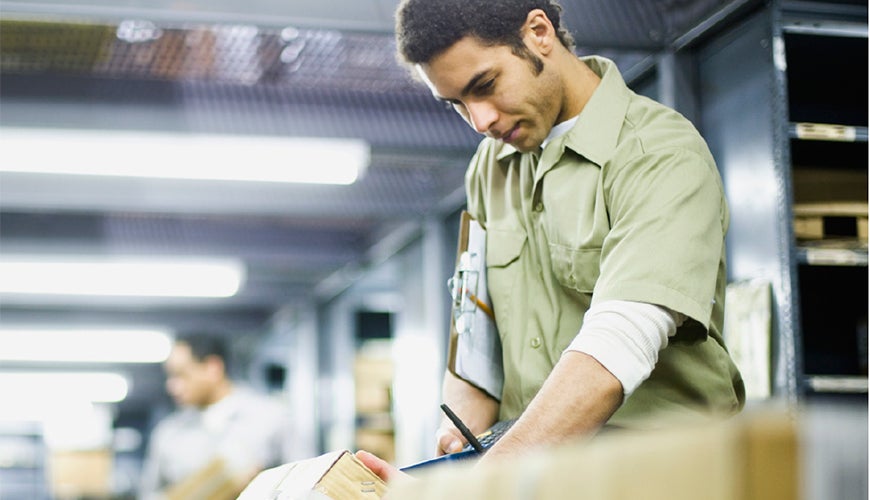 Male sorting packages in postal centre