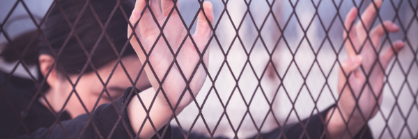 Woman peering through fence