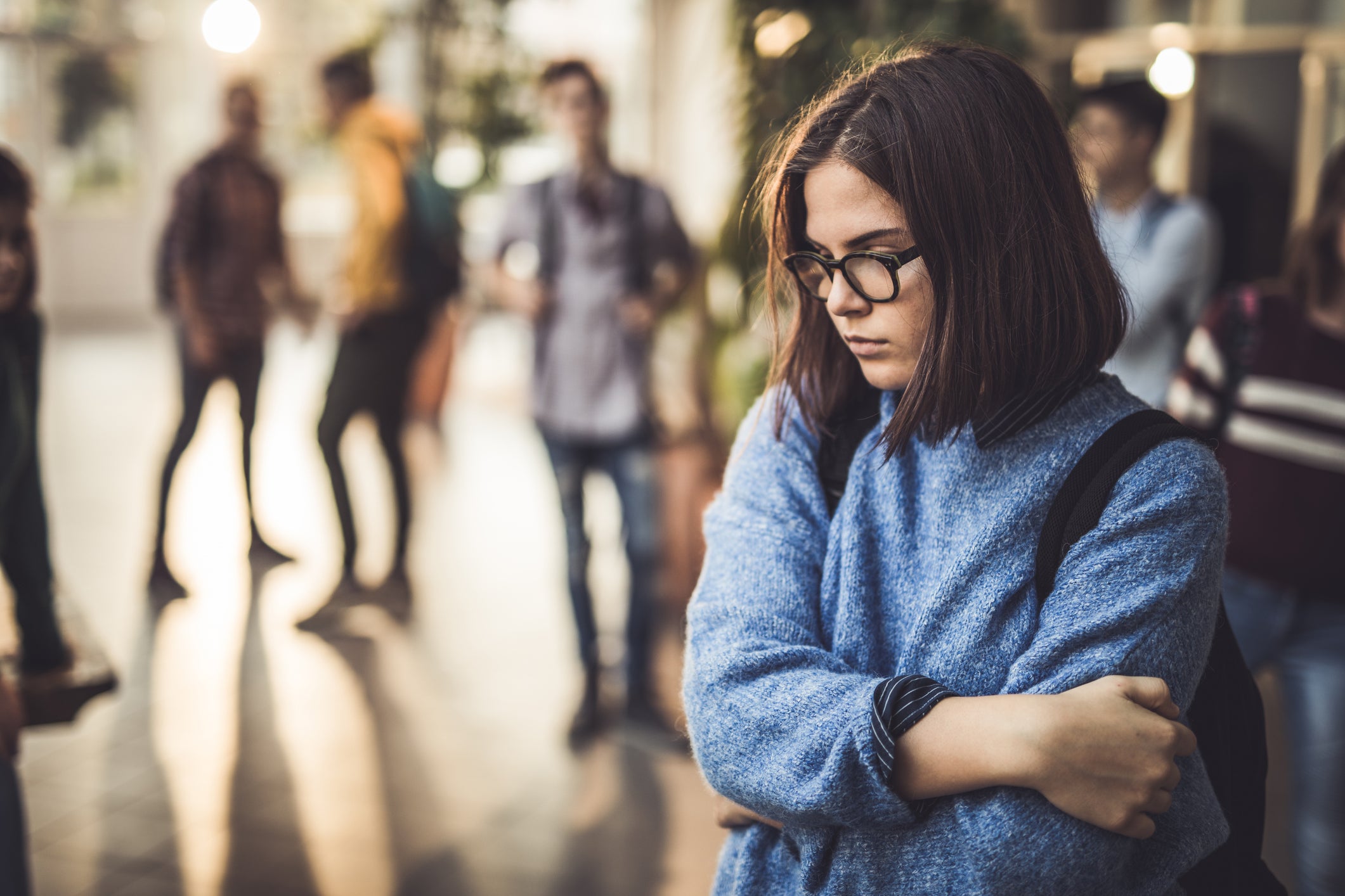 Unahappy female teenage student being excluded