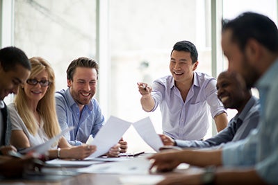 People in a meeting sitting around a desk.