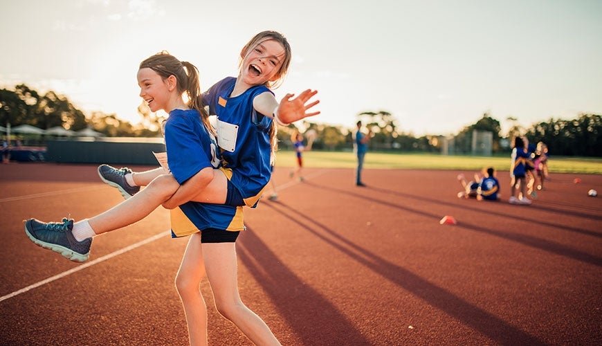 Child piggybacking another at sport carnival