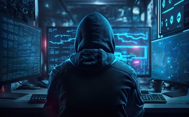 Hacker in front of computer screens