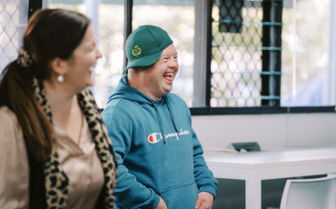 A woman and a man smiling and laughing together.