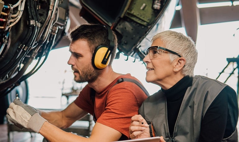 man and woman working on an aircraft