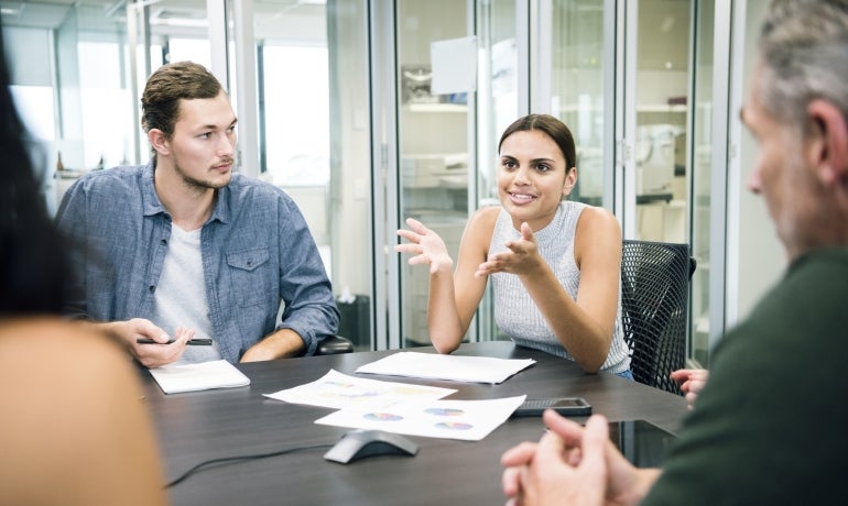 Aboriginal businesswoman explaining to colleagues in business meeting