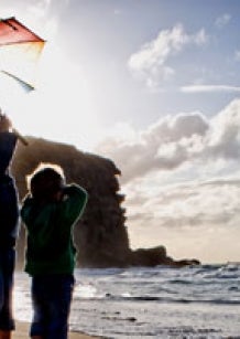 Photo: Children on a beach with an umbrella