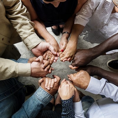 Group of diverse hands holding each other in supportive teamwork