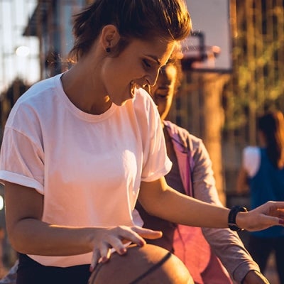 woman playing basketball with friends