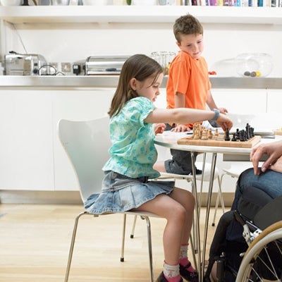 Mother with disability playing chess with her children