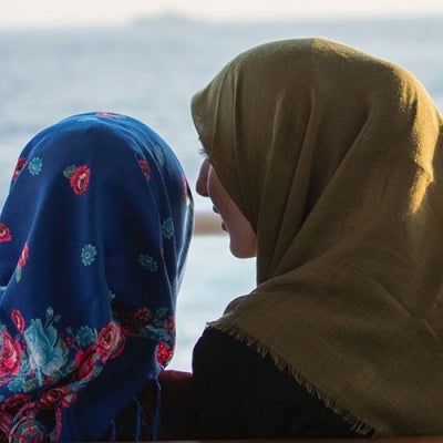 Two Muslim women talking near the ocean