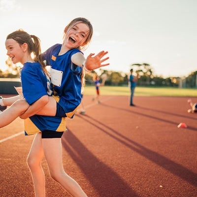 Child piggybacking another at sport carnival