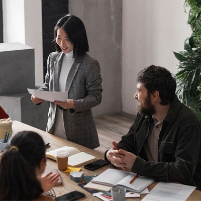 High angle portrait of diverse group of business people meeting at table in modern office interior decorated by plants.