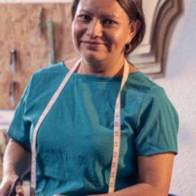 Beautiful woman working in the tailoring industry poses in front of the camera for a portrait.