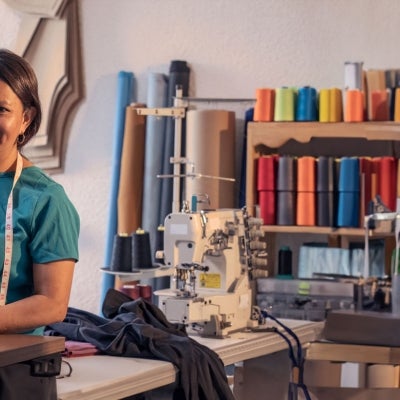 Beautiful woman working in the tailoring industry poses in front of the camera for a portrait.