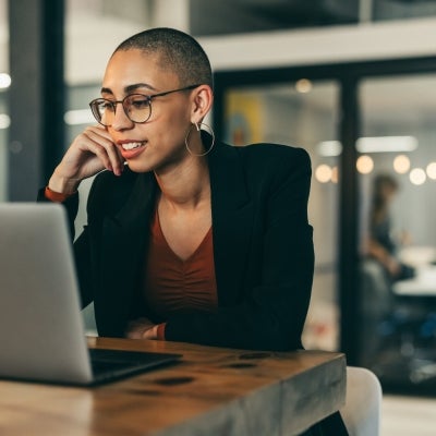 Business woman attending a virtual meeting in an office.