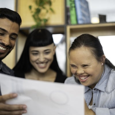 Group of business people (including Special Needs Woman) discussing new project at modern startup office stock photo.