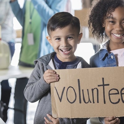 children with volunteer sign